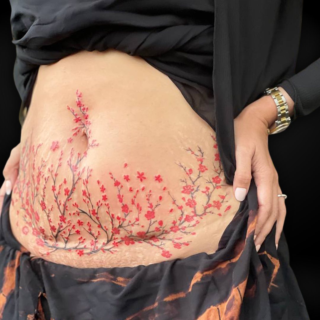a red tattoo on a girl's belly